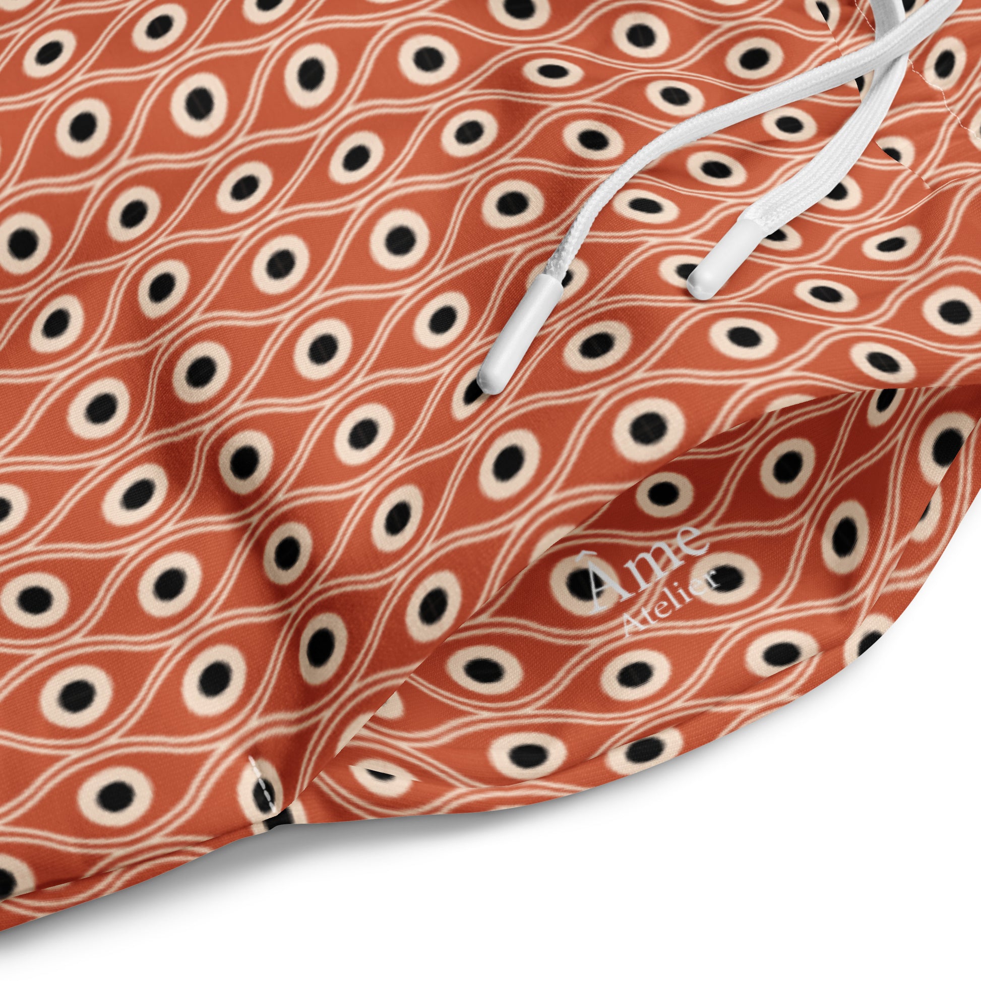 Close up of L'œil de paon pants in terracotta with peacock pattern